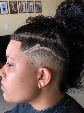 Undercut com freestyle de linha curva e cabelo cacheado preso
