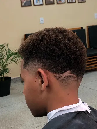 Degradê com topo crespo e risco curvo na nuca