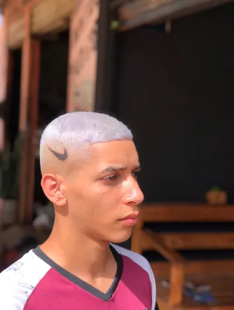 Cabelo platinado com desenho de logo esportivo na lateral